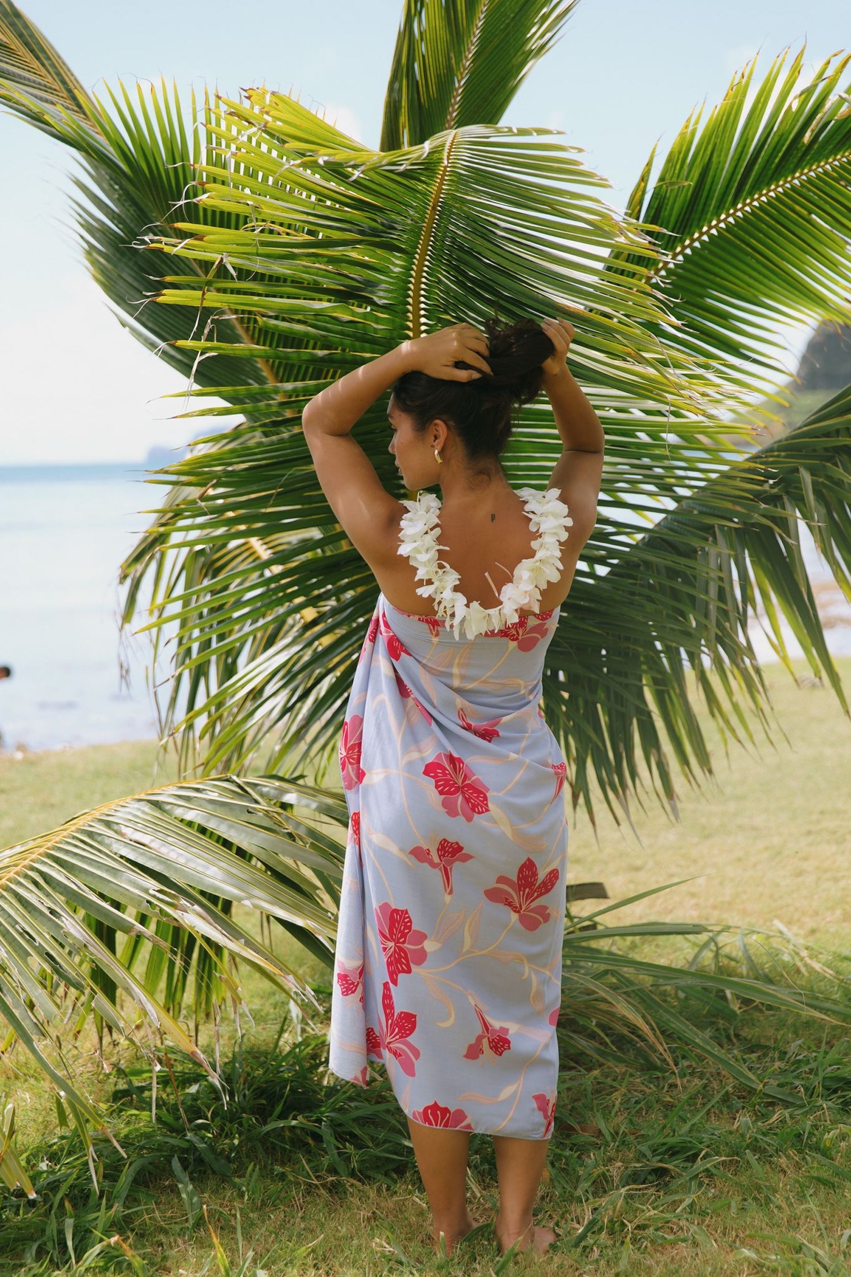 woman with brown hair wearing light lavender hibiscus pareo