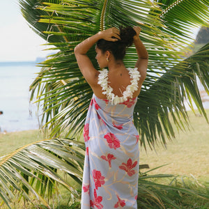 woman with brown hair wearing light lavender hibiscus pareo