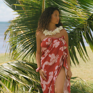 woman with brown hair wearing red pareo with light pink ginger + lei print