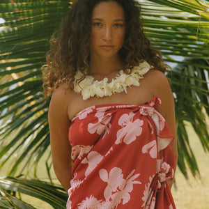 woman with brown hair wearing red pareo with light pink ginger + lei print