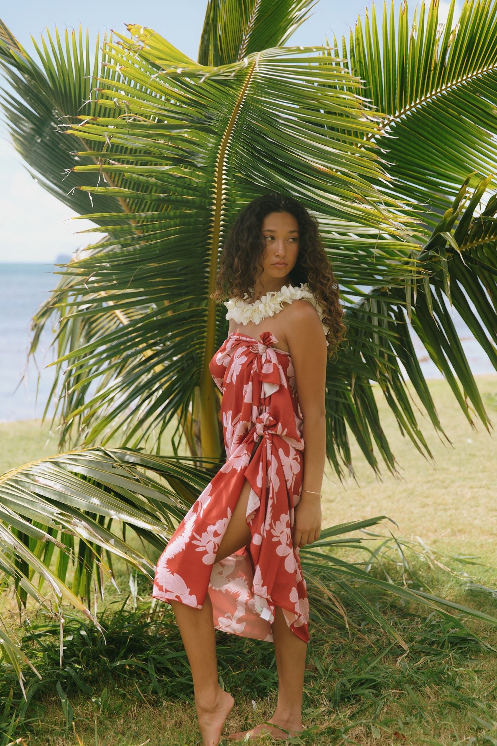 woman with brown hair wearing red pareo with light pink ginger + lei print