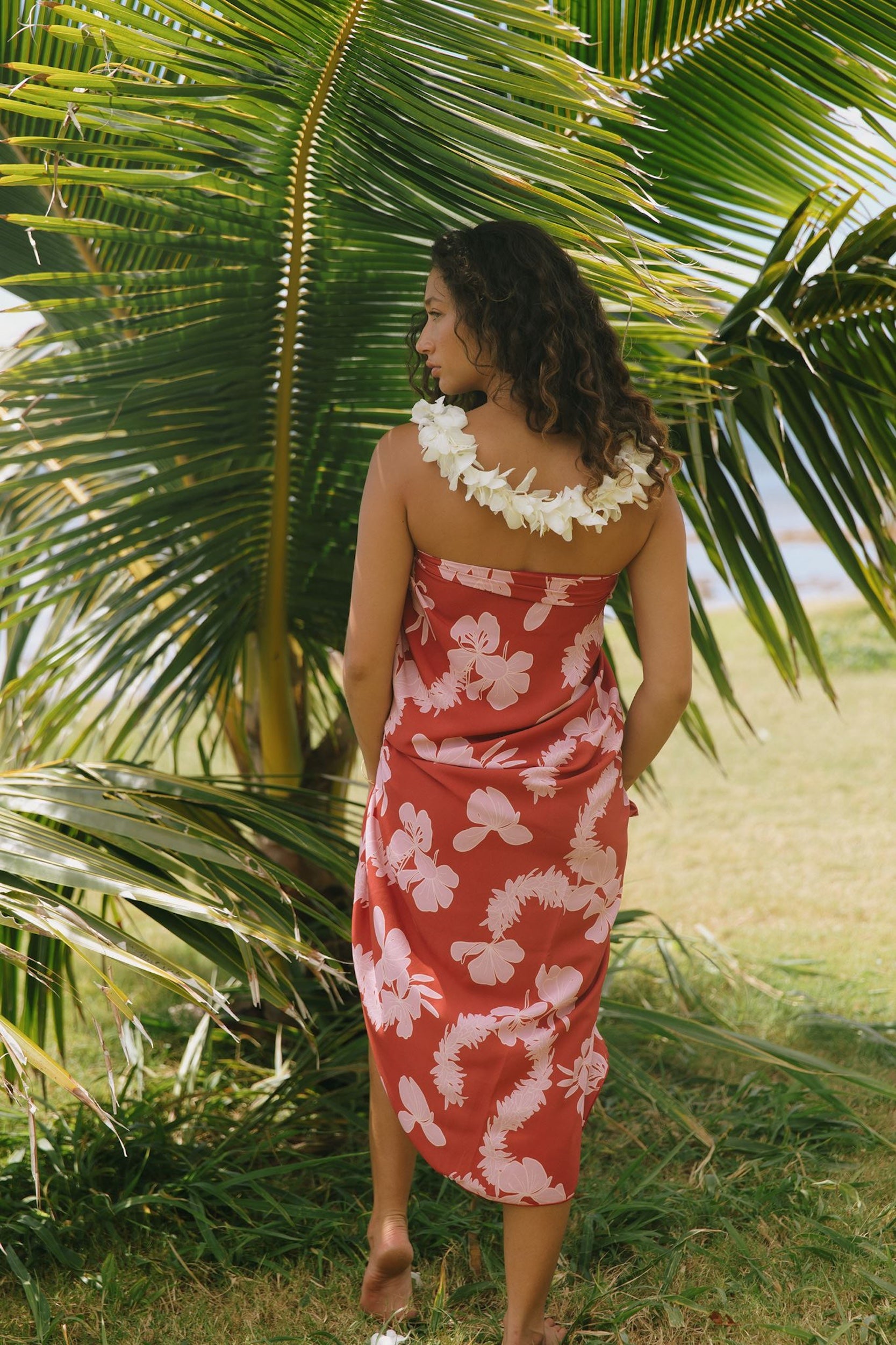 woman with brown hair wearing red pareo with light pink ginger + lei print