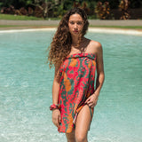 woman with brown hair wearing a colorful pareo with tropical lei print