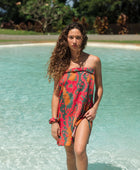 woman with brown hair wearing a colorful pareo with tropical lei print