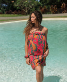 woman with brown hair wearing a colorful pareo with tropical lei print