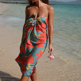 woman with brown hair wearing green pareo with orange and yellow lei pua print