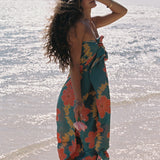 woman with brown hair wearing green pareo with orange and yellow lei pua print