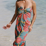 woman with brown hair wearing green pareo with orange and yellow lei pua print