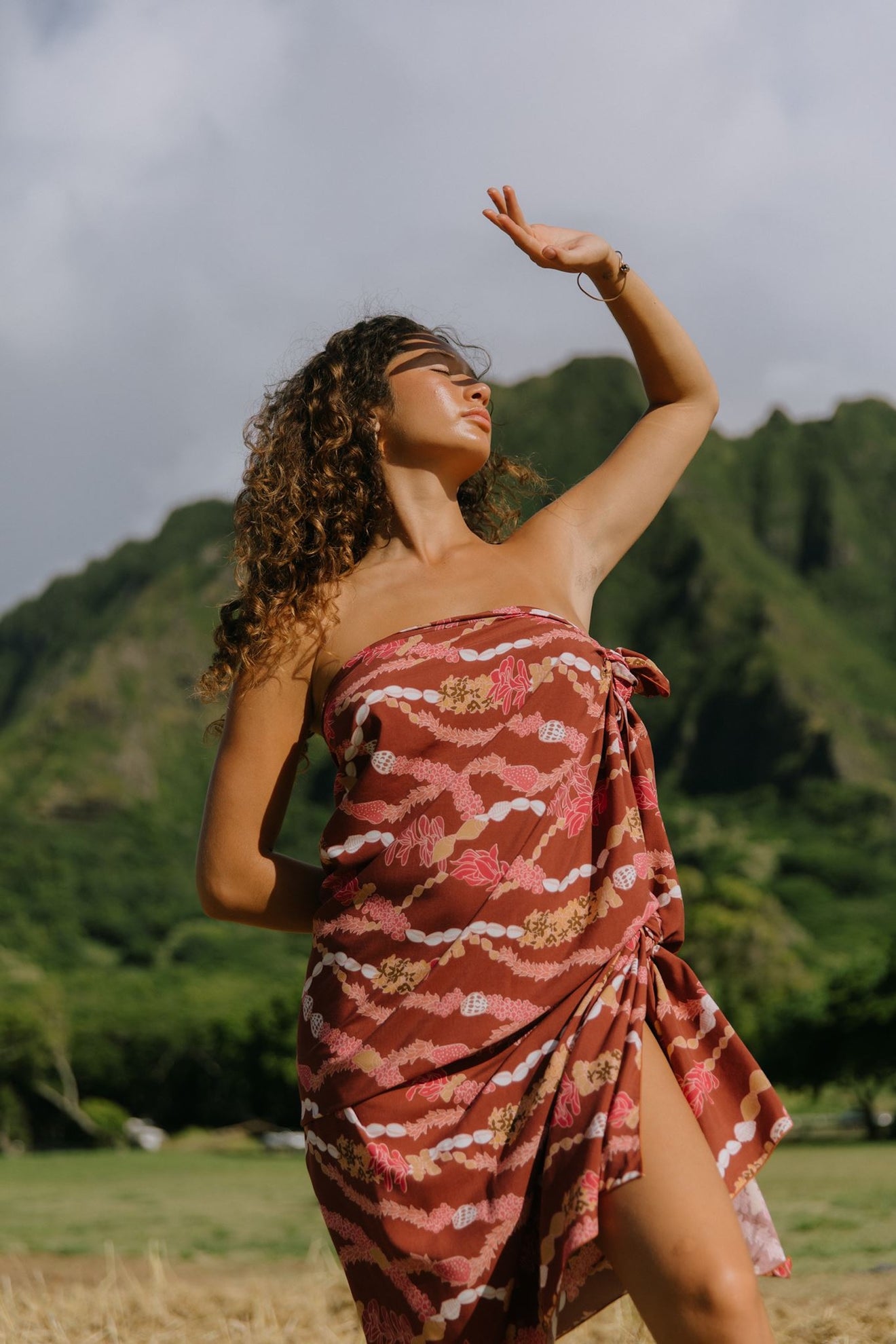 woman with brown hair wearing red brown pareo with lei print