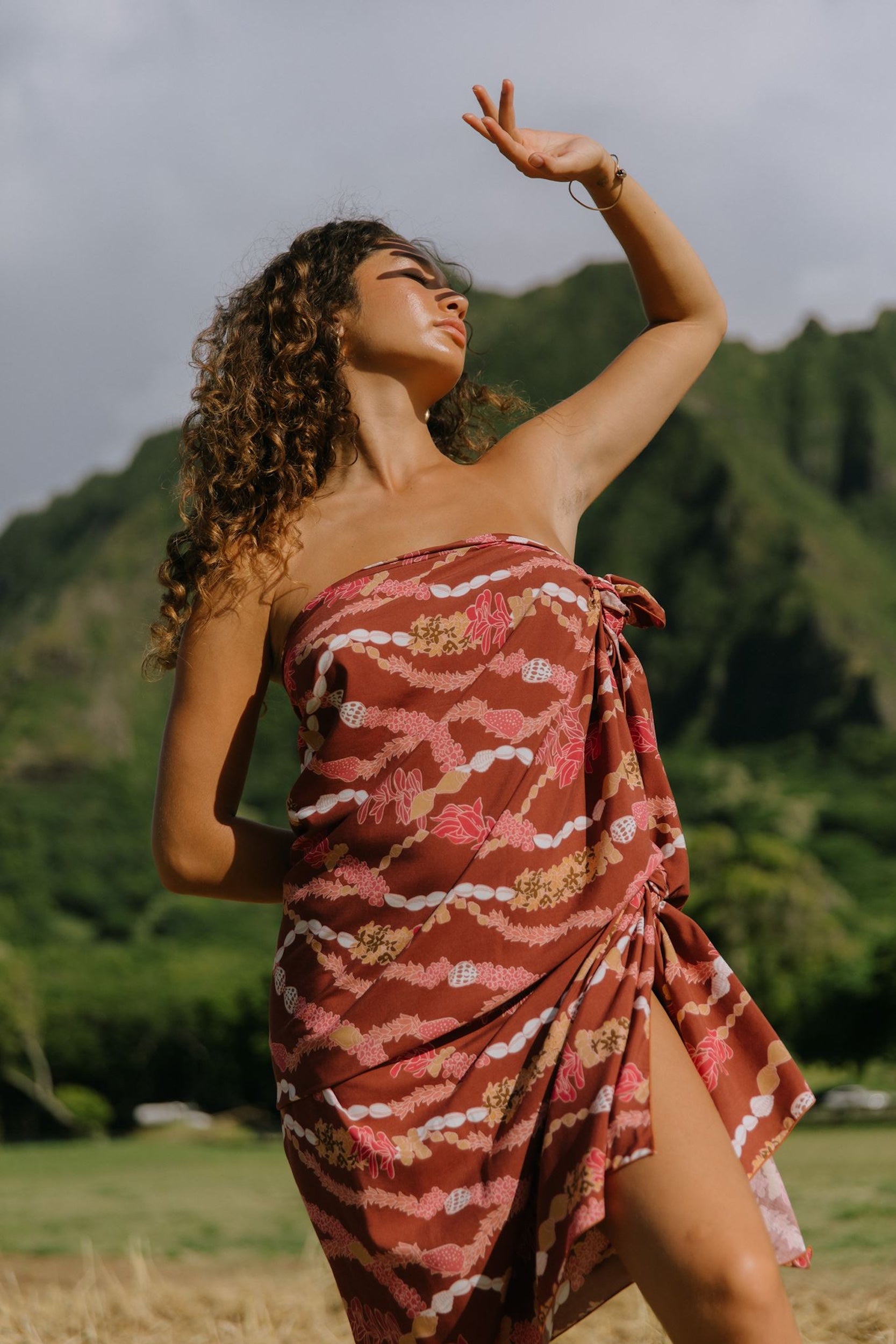 woman with brown hair wearing red brown pareo with lei print