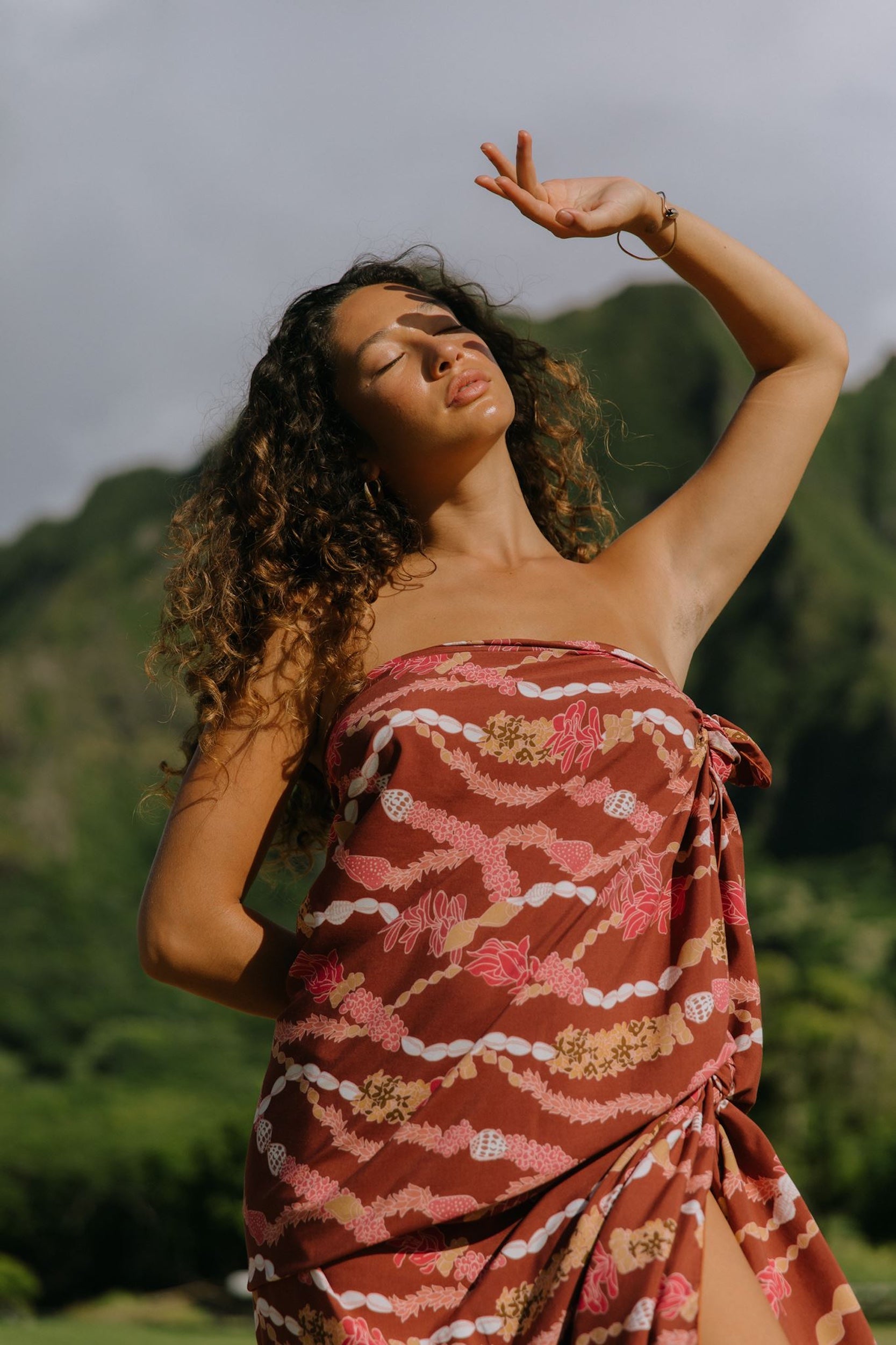 woman with brown hair wearing red brown pareo with lei print