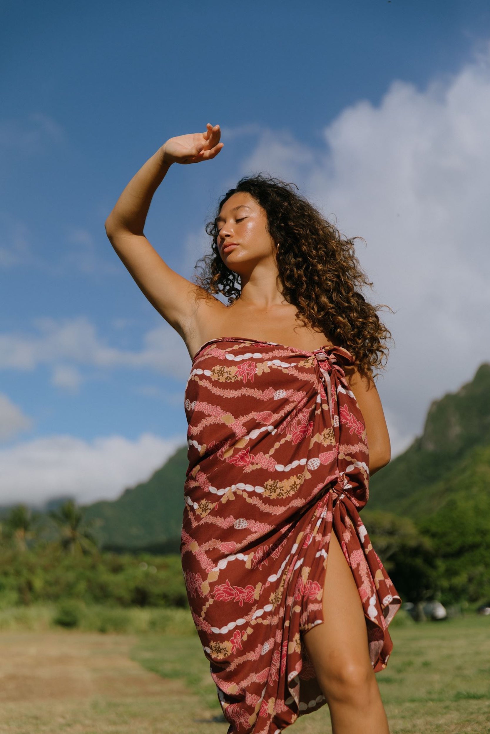 woman with brown hair wearing red brown pareo with lei print