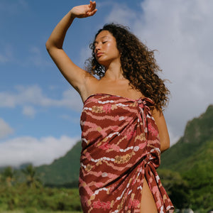 woman with brown hair wearing red brown pareo with lei print