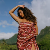 woman with brown hair wearing red brown pareo with lei print