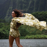 woman with brown hair wearing a pareo in a green color with naupaka pattern throughout. 