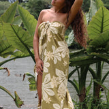 woman with brown hair wearing a pareo in a green color with naupaka pattern throughout. 