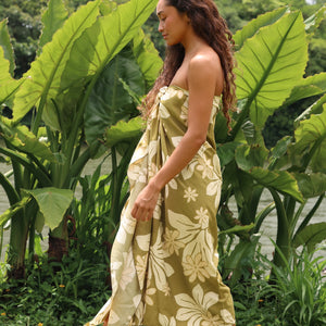 woman with brown hair wearing a pareo in a green color with naupaka pattern throughout. 