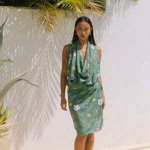 woman with brown hair wearing lush green pareo with puakenikeni print