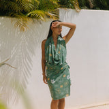 woman with brown hair wearing lush green pareo with puakenikeni print