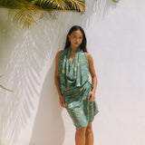 woman with brown hair wearing lush green pareo with puakenikeni print