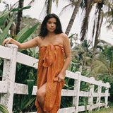 woman with brown hair wearing an orange puakenikeni pareo