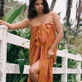 woman with brown hair wearing an orange puakenikeni pareo