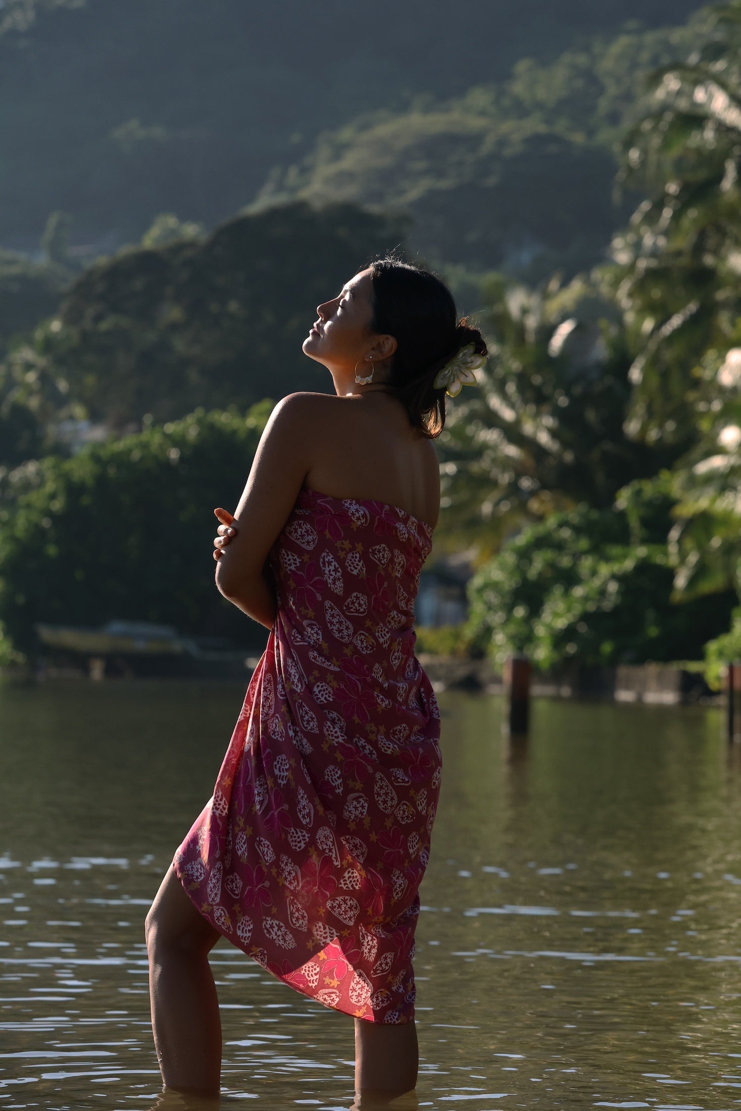 woman wearing a pareo wrap with shella and pua print in pink