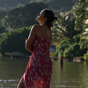 woman wearing a pareo wrap with shella and pua print in pink