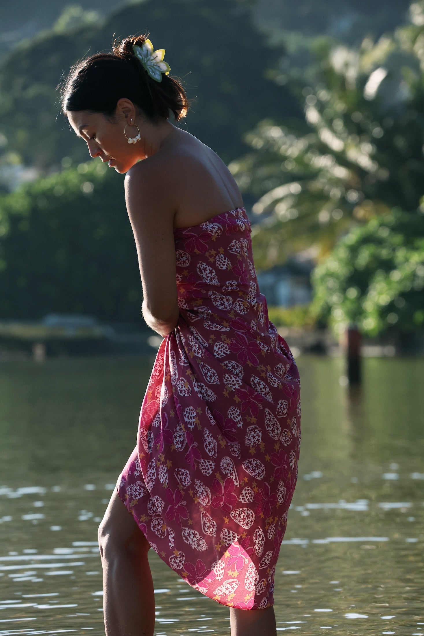 woman wearing a pareo wrap with shella and pua print in pink