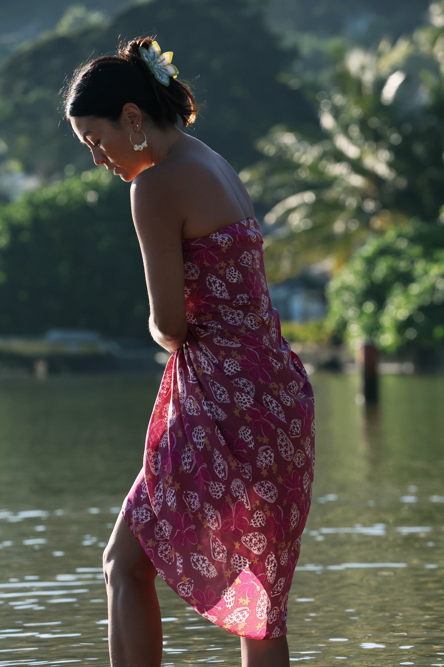 woman wearing a pareo wrap with shella and pua print in pink