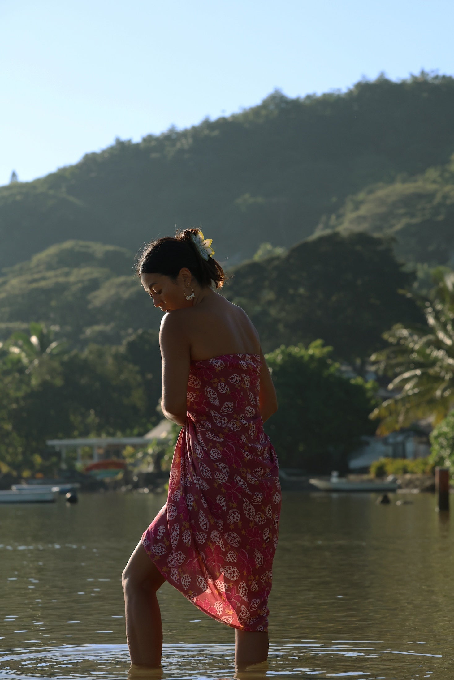woman wearing a pareo wrap with shella and pua print in pink