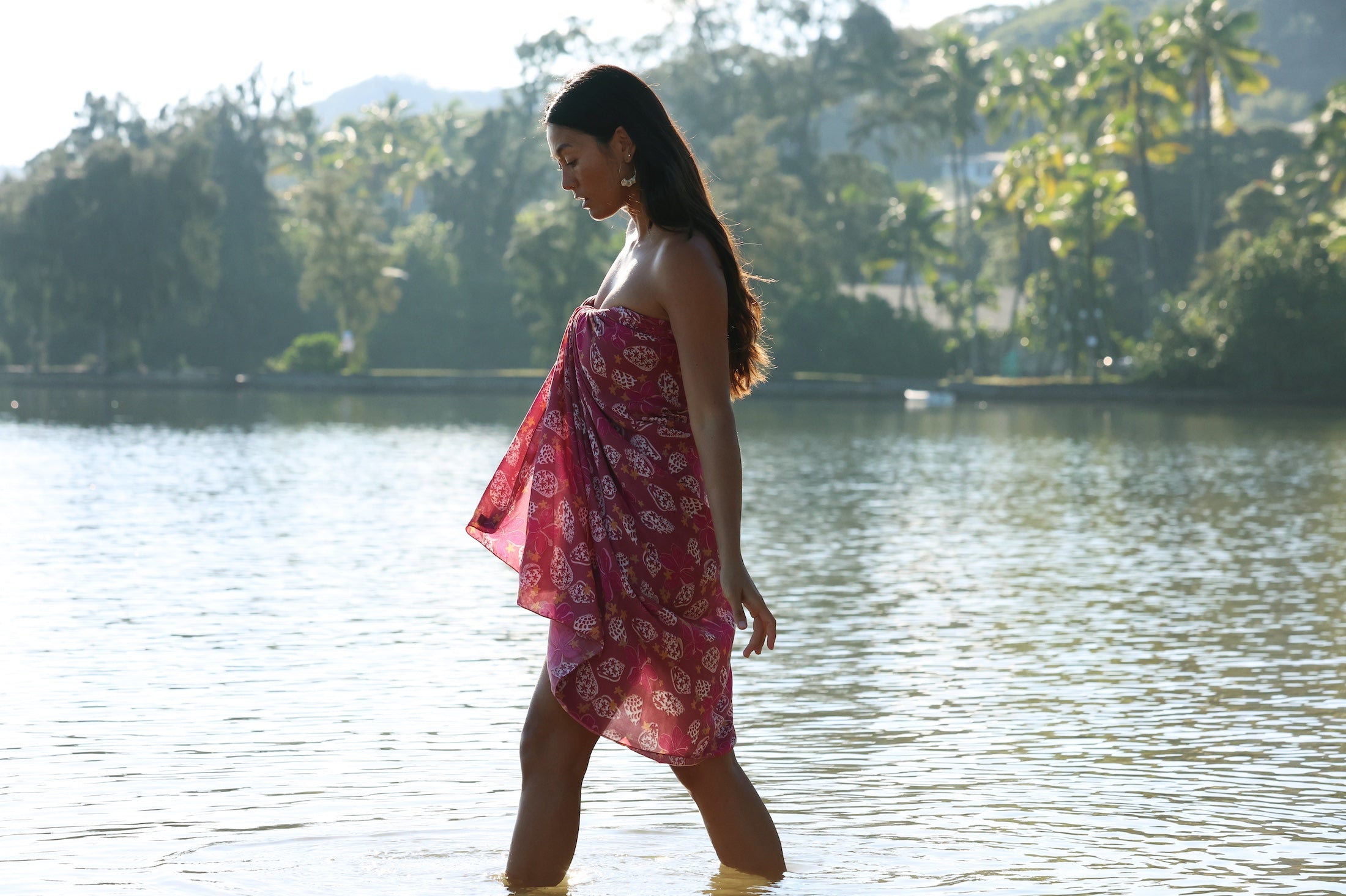 woman wearing a pareo wrap with shella and pua print in pink