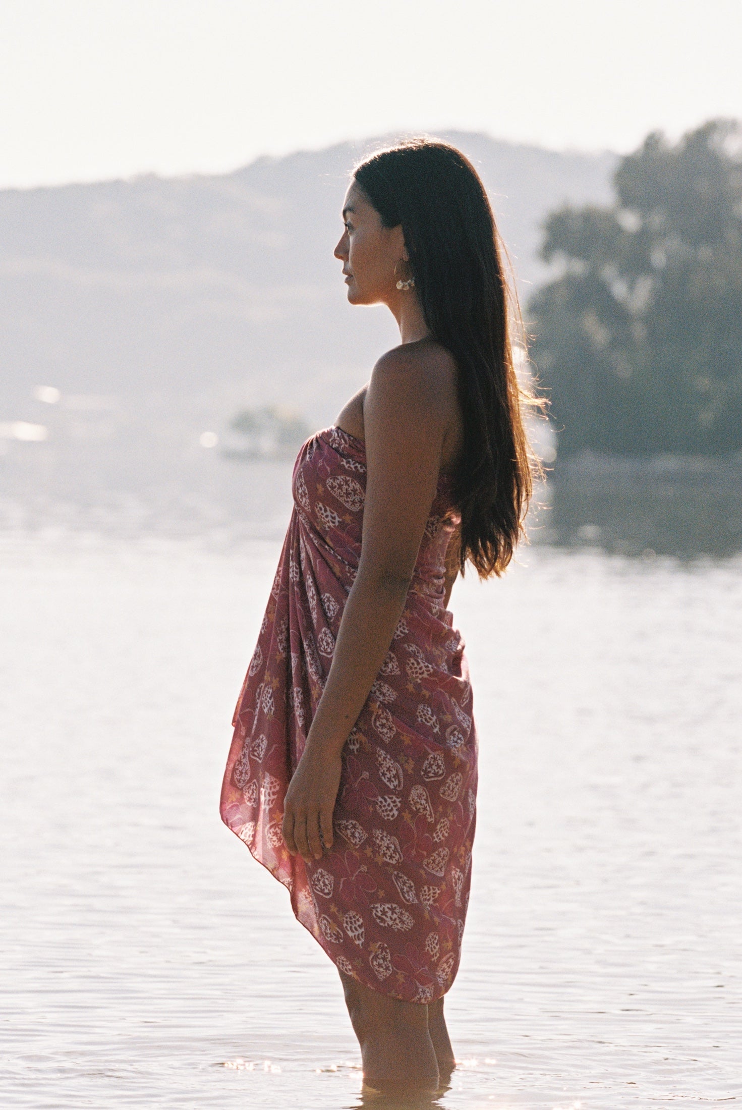 woman wearing a pareo wrap with shella and pua print in pink
