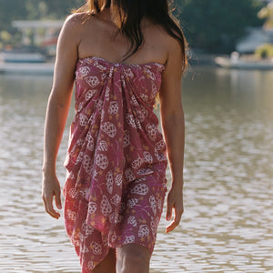 woman wearing a pareo wrap with shella and pua print in pink