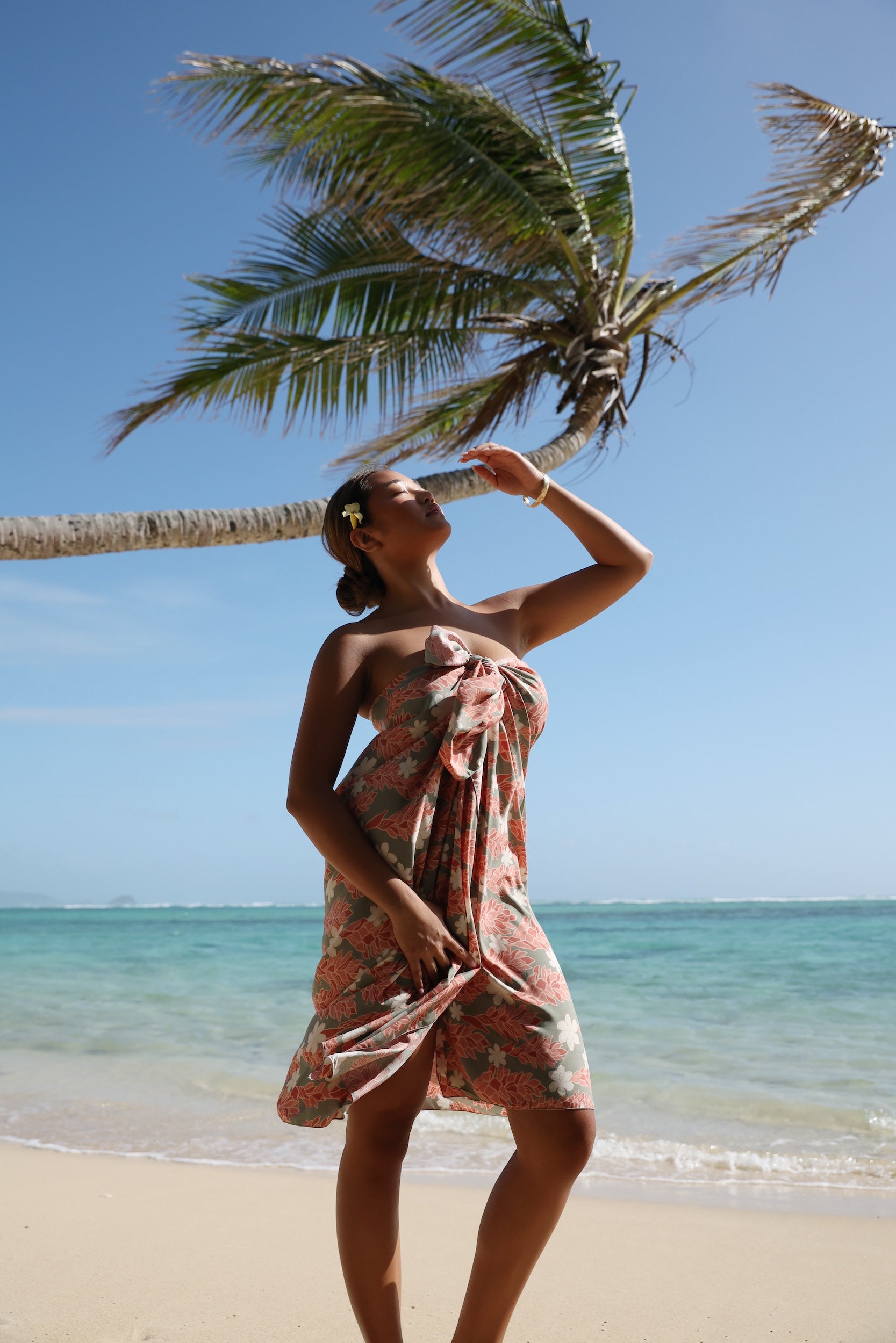 woman with brown hair wearing jade colored pareo with tiare ginger print
