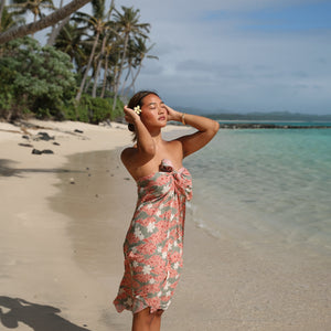 woman with brown hair wearing jade colored pareo with tiare ginger print