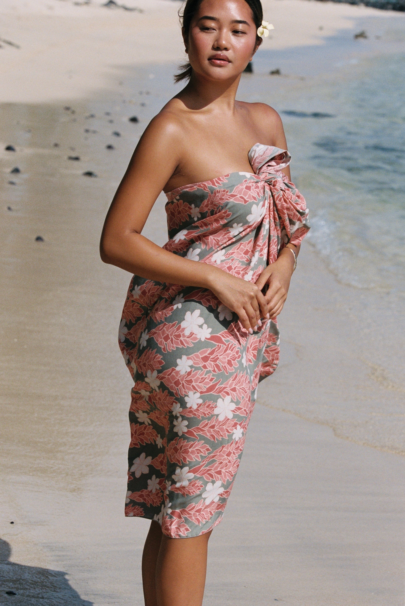 woman with brown hair wearing jade colored pareo with tiare ginger print