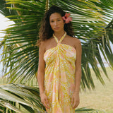 woman with brown hair wearing green yellow colored pareo with white and pink flower print
