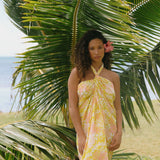woman with brown hair wearing green yellow colored pareo with white and pink flower print