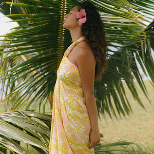 woman with brown hair wearing green yellow colored pareo with white and pink flower print
