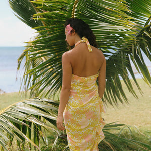 woman with brown hair wearing green yellow colored pareo with white and pink flower print