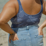 woman wearing a bodysuit with blue hibiscus pattern