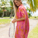 woman wearing a pink v neck button up mini dress with lei print