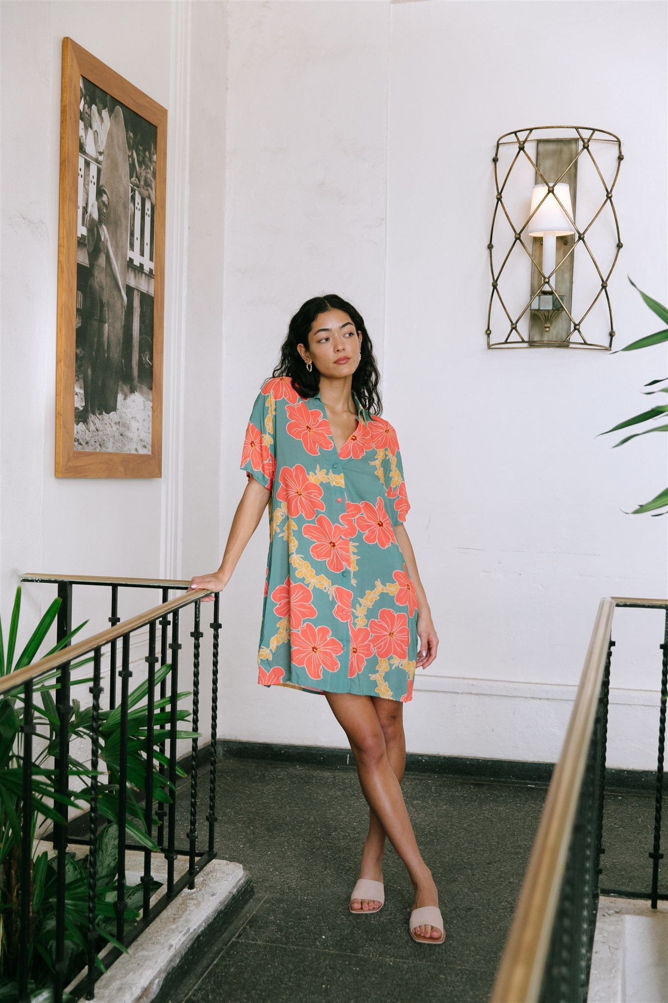woman with brown hair wearing collared button down dress with orange and yellow lei pua print