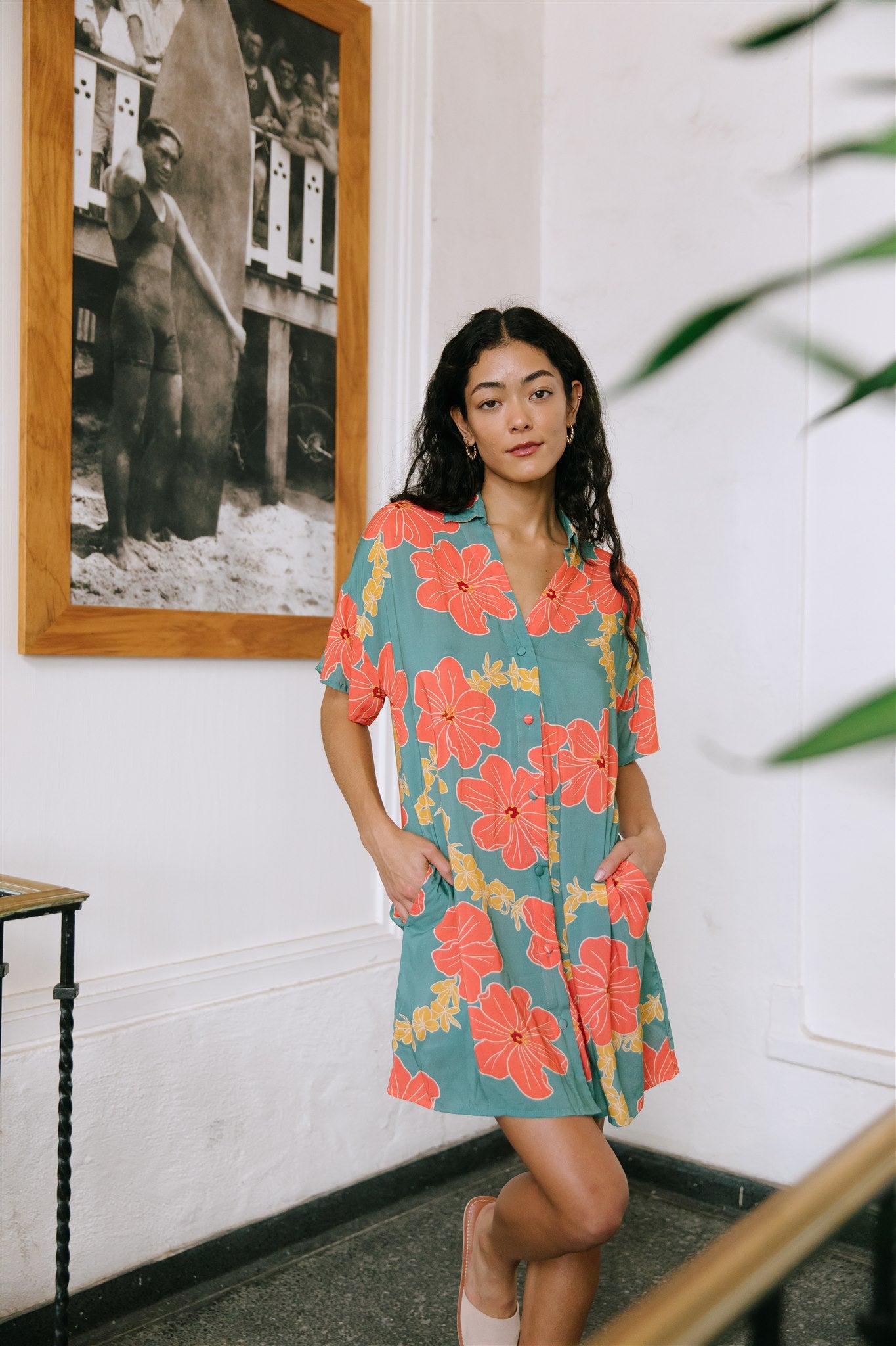 woman with brown hair wearing collared button down dress with orange and yellow lei pua print