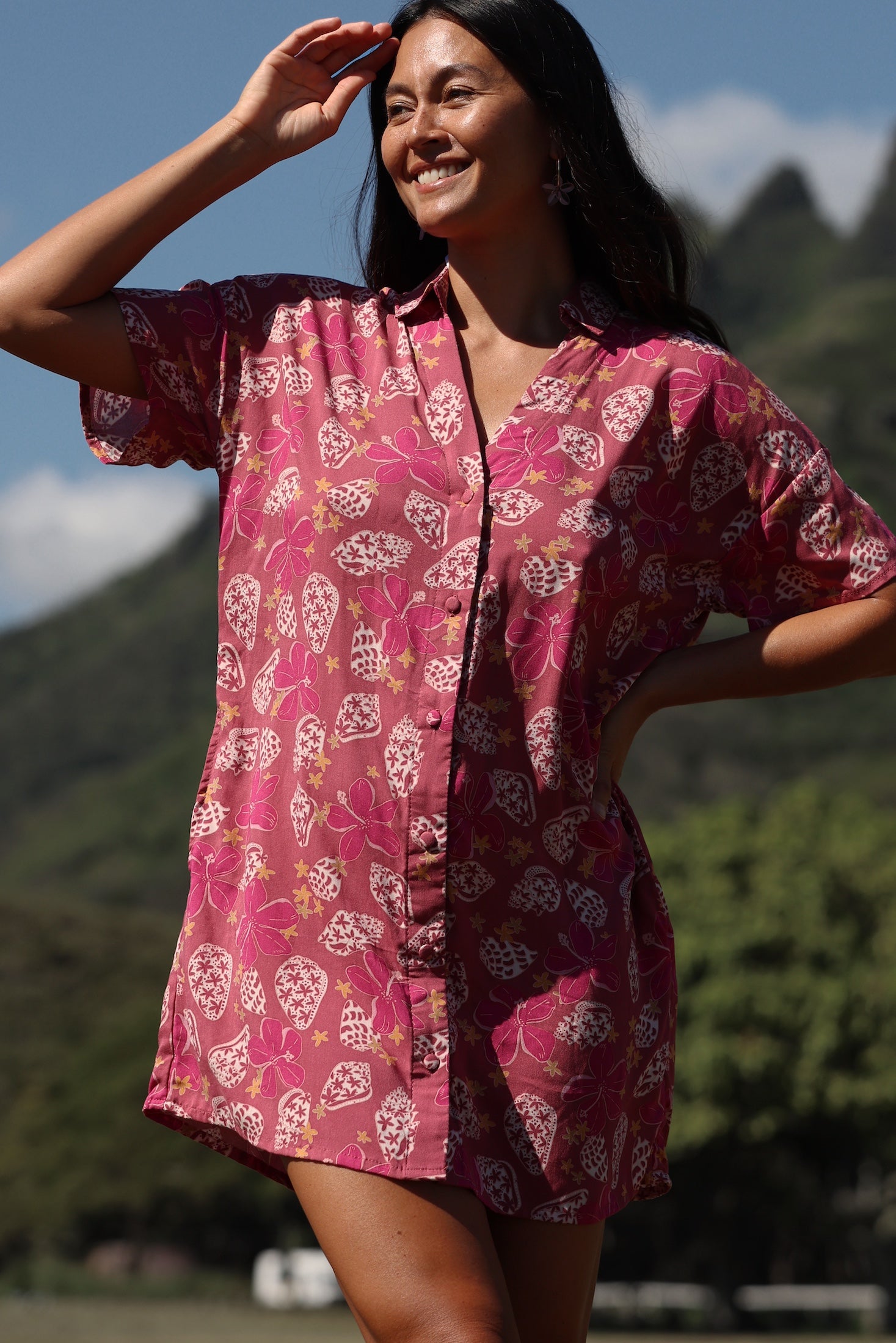 woman with brown hair wearing a collared button up dress with shells and pua print in pink color