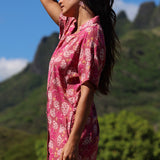 woman with brown hair wearing a collared button up dress with shells and pua print in pink color