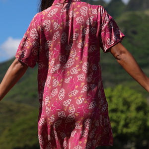 woman with brown hair wearing a collared button up dress with shells and pua print in pink color
