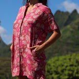 woman with brown hair wearing a collared button up dress with shells and pua print in pink color