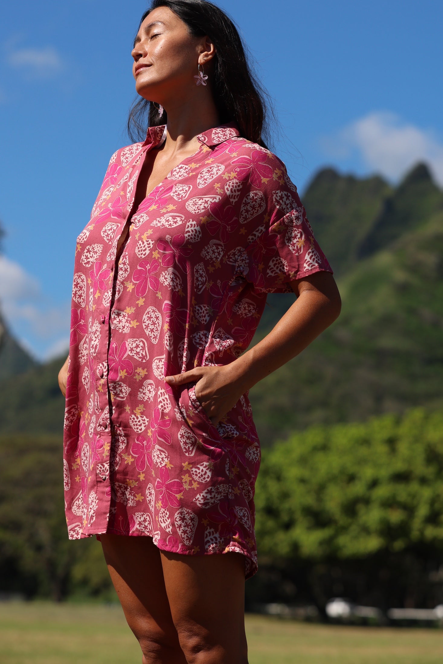 woman with brown hair wearing a collared button up dress with shells and pua print in pink color